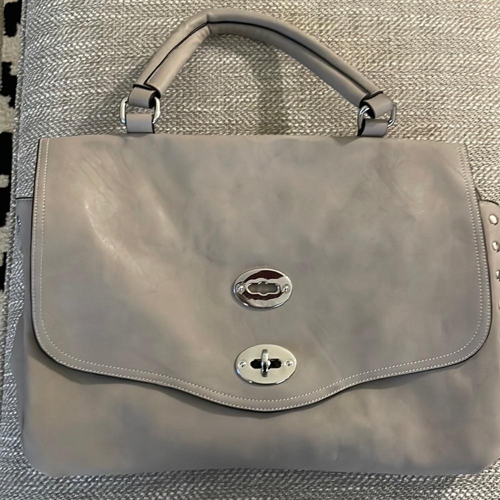 Purse Bag with snap closure.  Inner lining with divider. 2 zipper pockets.